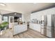Open kitchen featuring an island with seating, white cabinetry, and stainless steel appliances at 4950 Mt Cameron Dr, Brighton, CO 80601