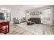 Bright living room with light wood floors, modern decor, and ample seating with large windows at 4950 Mt Cameron Dr, Brighton, CO 80601