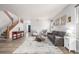 Bright living room with light wood floors, modern decor, and ample seating with staircase to the left at 4950 Mt Cameron Dr, Brighton, CO 80601