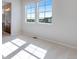 Bright bedroom featuring neutral carpet, two windows, and an ensuite bathroom at 16778 W 93Rd Pl, Arvada, CO 80007