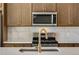 Kitchen featuring stainless steel microwave and range, light brown cabinets and a golden faucet at 16778 W 93Rd Pl, Arvada, CO 80007
