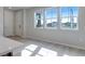 Bright living room showcasing beautiful wood floors and large windows overlooking the community at 16778 W 93Rd Pl, Arvada, CO 80007