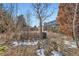 Landscaped backyard features a deck and mature trees in a partially snow-covered setting at 4666 Cornish Way, Denver, CO 80239