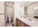 Standard bathroom featuring dual sinks, tile flooring, and a combined toilet and shower at 4666 Cornish Way, Denver, CO 80239