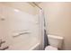 Bright bathroom featuring a white-tiled tub and shower with a clean, modern toilet at 4666 Cornish Way, Denver, CO 80239