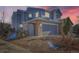 Charming two-story home features a gray facade and a convenient two-car garage at twilight at 4666 Cornish Way, Denver, CO 80239