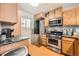 Updated kitchen featuring stainless steel appliances, wooden cabinets, and modern fixtures at 4666 Cornish Way, Denver, CO 80239