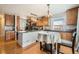 Eat-in kitchen with wooden cabinets, an island with stone countertops, and stainless steel appliances at 4666 Cornish Way, Denver, CO 80239