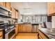 Well-lit kitchen featuring stainless steel appliances, granite countertops, and an open view to the living area at 4666 Cornish Way, Denver, CO 80239