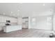 Bright, open kitchen with white cabinets, stainless steel appliances, and wood-look floors at 45922 Gentry Ave, Bennett, CO 80102