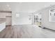 Open-concept living room with wood-look flooring, ample natural light, and sliding glass doors at 45922 Gentry Ave, Bennett, CO 80102