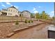 Fenced backyard featuring a brick patio, rock garden, landscaping, and retaining wall at 1820 Ghost Dance Cir, Castle Rock, CO 80108