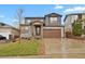 Charming two-story home with a stone facade and a well-maintained lawn at 1820 Ghost Dance Cir, Castle Rock, CO 80108