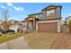 A two-story home featuring stone accents, a front yard, and an attached garage at 1820 Ghost Dance Cir, Castle Rock, CO 80108