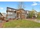 Two story home with stone facade, a front lawn, an attached garage, and a driveway at 1820 Ghost Dance Cir, Castle Rock, CO 80108