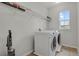 Bright laundry room with new washer and dryer and overhead shelving at 1820 Ghost Dance Cir, Castle Rock, CO 80108