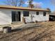 Backyard featuring a concrete patio, white siding on house, grass, and mature landscaping at 16390 E Bates Dr, Aurora, CO 80013