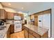 Traditional kitchen features granite countertops, wood cabinets, and modern white appliances at 2420 S Ellis Ct, Lakewood, CO 80228