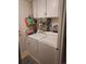 Functional laundry room with a washer, dryer, and white storage cabinets at 2420 S Ellis Ct, Lakewood, CO 80228