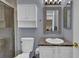 Cozy bathroom featuring vanity with brown countertop, a toilet, a shower with glass doors, and gray-blue wall color at 9595 Marmot Ridge Cir, Littleton, CO 80125