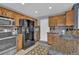 Traditional eat-in kitchen featuring tile floors, granite counters, and wood cabinets at 9595 Marmot Ridge Cir, Littleton, CO 80125