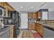 A cozy kitchen featuring wood cabinets, stainless steel appliances, and a tile backsplash at 9595 Marmot Ridge Cir, Littleton, CO 80125