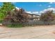Back of the house with a large pergola, mature trees, and a well-maintained fence at 9244 E 37Th Ave, Denver, CO 80238