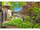 Landscaped backyard with lush greenery, mature trees and a covered patio with outdoor dining area at 9244 E 37Th Ave, Denver, CO 80238
