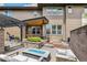 Spacious backyard with an outdoor kitchen, seating area, covered patio, and manicured landscaping at 9244 E 37Th Ave, Denver, CO 80238