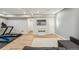 Finished basement featuring a home gym, light wood flooring, and a wall-mounted television at 9244 E 37Th Ave, Denver, CO 80238