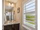 Bathroom with granite counters, vessel sink, framed mirror and modern fixtures at 9244 E 37Th Ave, Denver, CO 80238