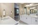 Bright bathroom with double vanity sinks, modern fixtures, and views into an adjacent bedroom at 9244 E 37Th Ave, Denver, CO 80238