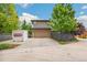 Charming two-story home with a well-manicured lawn, mature trees and a PODS Moving & Storage container at 9244 E 37Th Ave, Denver, CO 80238