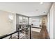 Second floor hallway with wood floors, metal stair railing, and a view of the front windows at 9244 E 37Th Ave, Denver, CO 80238
