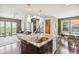 Open concept kitchen with island, sink, and stainless dishwasher flows into living and dining areas at 9244 E 37Th Ave, Denver, CO 80238