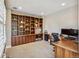 Home office with custom built-ins provides ample storage and workspace with hardwood finishes at 9244 E 37Th Ave, Denver, CO 80238