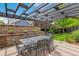 Covered patio with an outdoor dining set, brick retaining wall and lush landscaping at 9244 E 37Th Ave, Denver, CO 80238