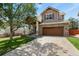 Charming two-story home showcasing a well-maintained front yard, inviting porch, and a brick two-car garage at 3912 Miners Candle Pl, Castle Rock, CO 80109