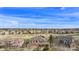 Expansive aerial view featuring the neighborhood's layout with houses nestled within a green landscape under a bright sky at 11065 W Rockland Dr, Littleton, CO 80127