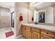 Bathroom vanity with sink, mirror, and shower over tub with glass door and linen closet at 11065 W Rockland Dr, Littleton, CO 80127