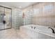 Bathroom featuring a soaking tub with tile surround and a glass block shower at 11065 W Rockland Dr, Littleton, CO 80127