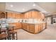 Spacious kitchen with wood cabinets, tile backsplash, and room for seating at 11065 W Rockland Dr, Littleton, CO 80127