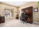Comfortable home office with a large window, built-in shelving, and a view of blossoming trees at 11065 W Rockland Dr, Littleton, CO 80127