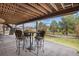Covered patio with table and chairs, overlooking backyard at 11065 W Rockland Dr, Littleton, CO 80127