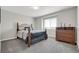 Cozy bedroom with a window, dresser, neutral walls, and soft carpet at 16680 Stroilway St, Hudson, CO 80642