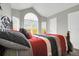 Well-lit bedroom featuring a large arched window that lets in natural light at 16680 Stroilway St, Hudson, CO 80642