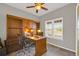 Home office features a large wooden desk, built-in shelves, and natural light from the windows at 16680 Stroilway St, Hudson, CO 80642