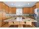 Spacious kitchen featuring wooden cabinets, granite countertops, stainless appliances, and a central island with seating at 16680 Stroilway St, Hudson, CO 80642