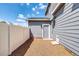 Practical side entrance with gravel pathway, door to the house, and a white fence at 16680 Stroilway St, Hudson, CO 80642