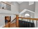 Upper-level view of the home's elegant wood and wrought iron staircase leading to the main level at 16680 Stroilway St, Hudson, CO 80642